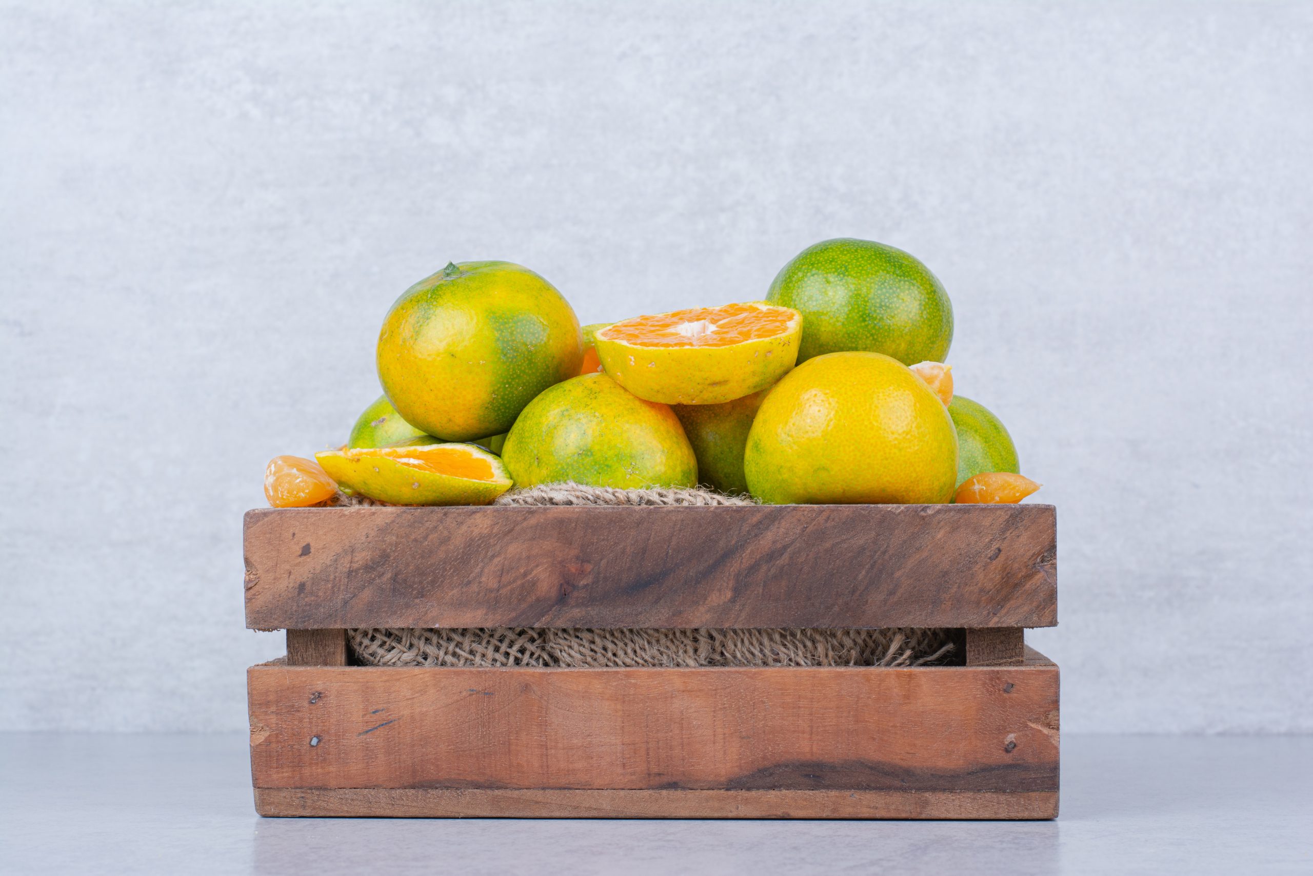 una canasta de madera llena de mandarina agria en blanco